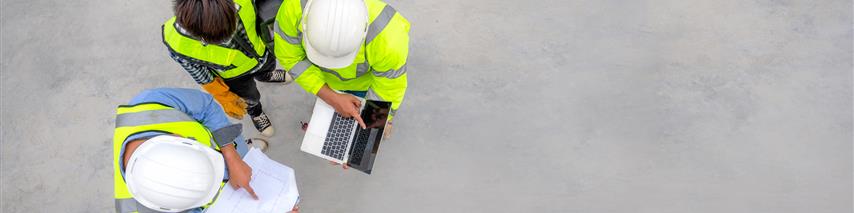 civil engineers inspect plans on construction site 